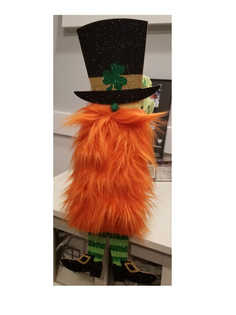 Leprechaun with an orange beard, a black top hat adorned with a green shamrock, green striped legs, and sparkling black shoes