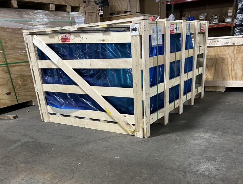 Slat crating for industrial holding tanks with protective wrapping for secure shipping and handling.